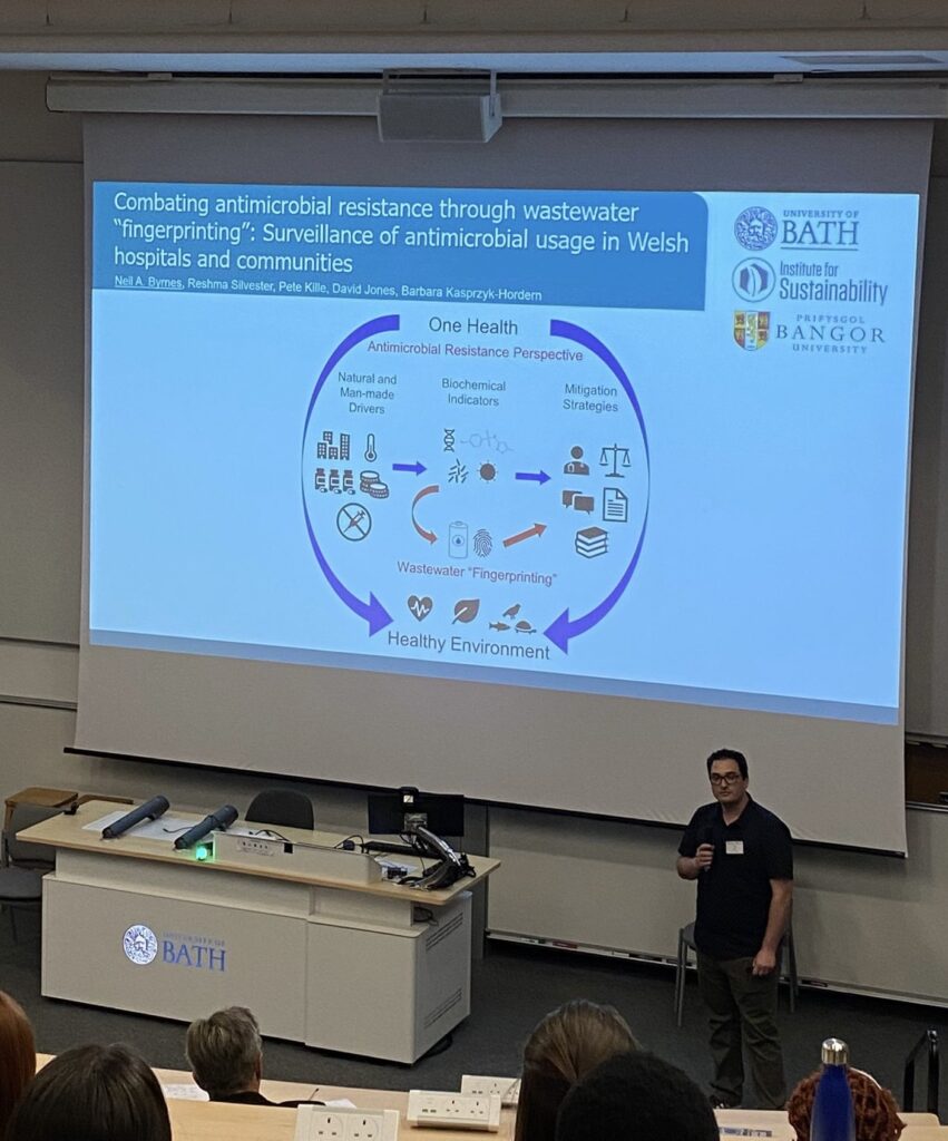 Dr. Neil Andrew Byrnes presenting a Three-Minute Thesis on his research titled "Combating antimicrobial resistance through wastewater 'fingerprinting': Surveillance of antimicrobial usage in Welsh hospitals and communities" at the Institute of Sustainability Summer Showcase 2023.